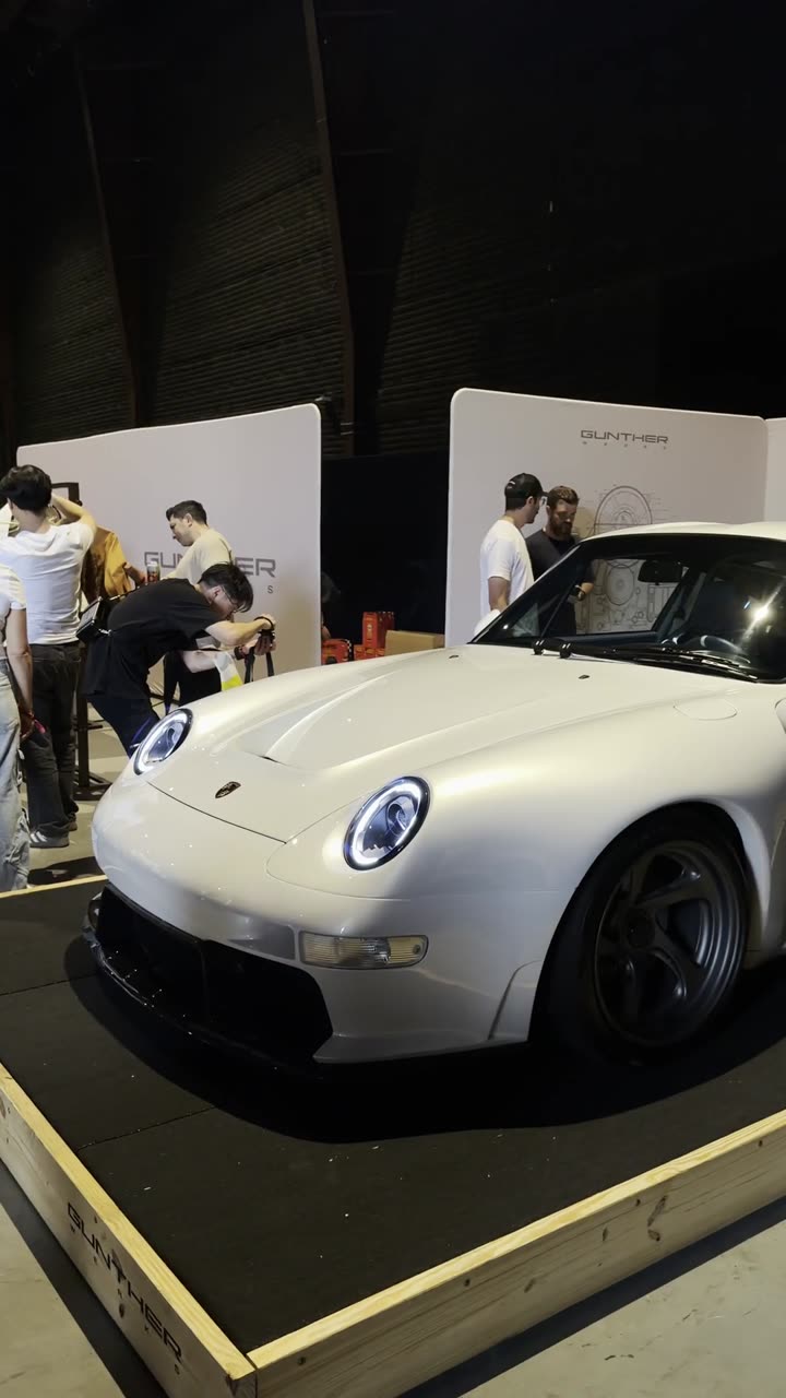A white Guntherwerks 993 surrounded by a crowd at a showcase